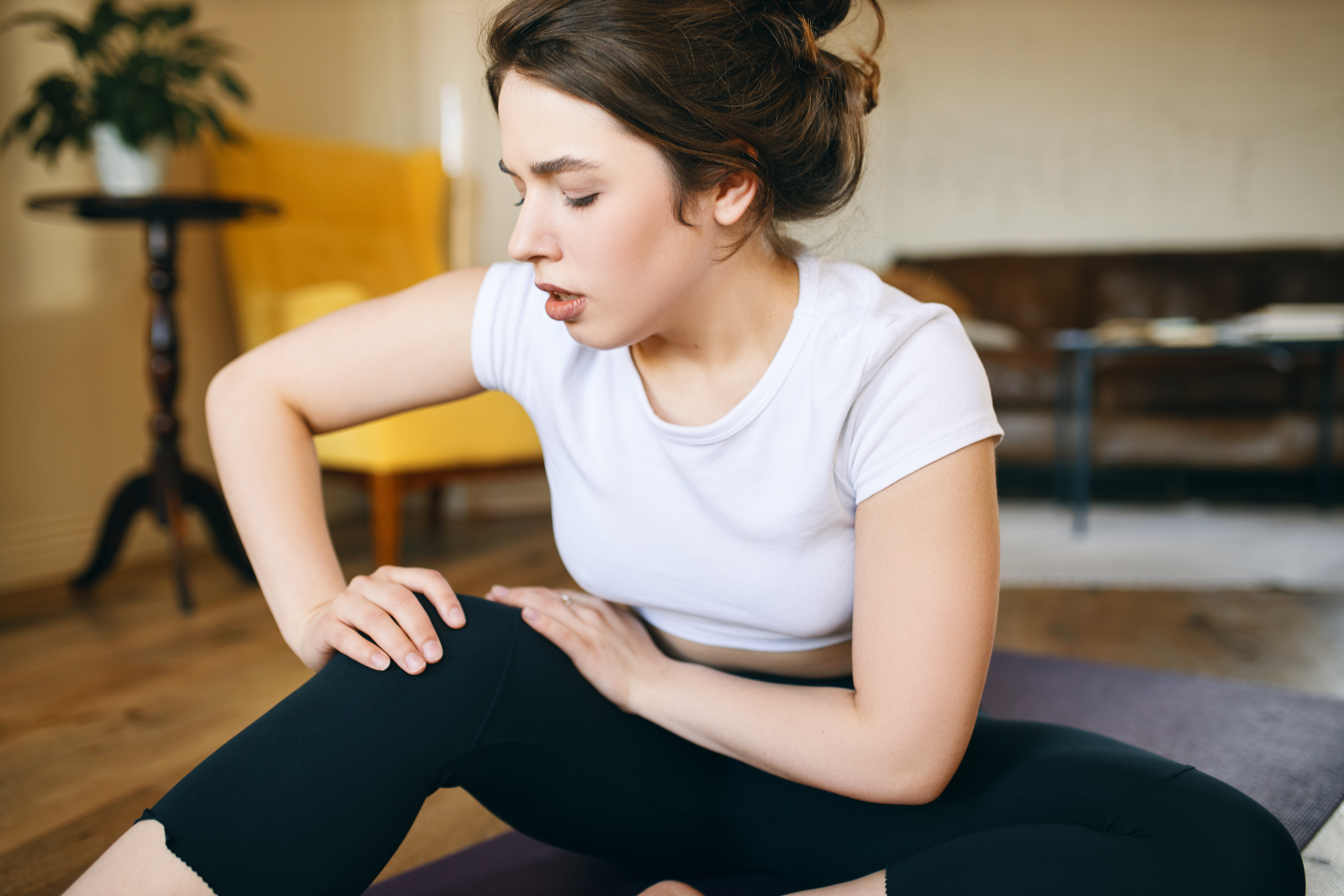 Frau hat Schmerzen bei Yoga | Juice Plus+